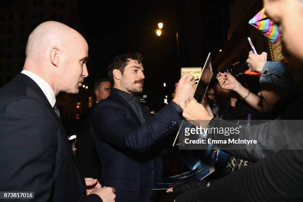 Actor Henry Cavill signs autographs for fans during the premiere of Warner Bros. Pictures' "Justice League" at Dolby Theatre on November 13, 2017 in...
