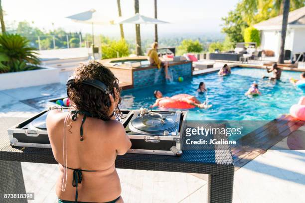 jonge vrouwelijke dj op een pool party - poolparty stockfoto's en -beelden