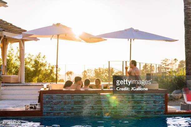 friends relaxing in a luxury hot tub outdoors at sunset - body issue celebration party stock pictures, royalty-free photos & images