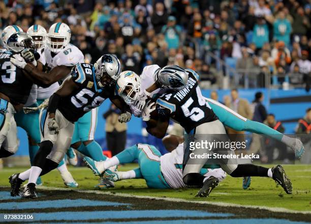 Julius Thomas of the Miami Dolphins dives for a touchdown against teammates Thomas Davis and Shaq Thompson of the Carolina Panthers during their game...