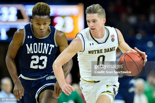 Notre Dame Fighting Irish guard Rex Pflueger brings up the ball against Mount St. Mary's Mountaineers guard Greg Alexander during the game between...