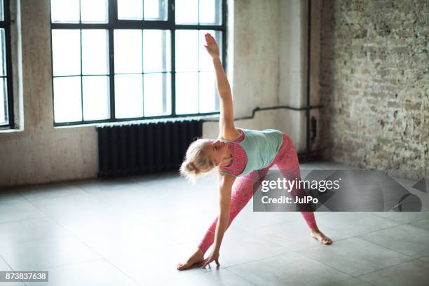 fitness classes - revolved triangle pose stock pictures, royalty-free photos & images