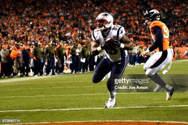 Dwayne Allen of the New England Patriots crosses the goal line for a touchdown as Von Miller of the Denver Broncos reacts to getting beat on the play...