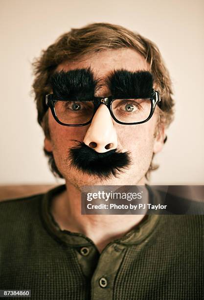 man wearing grouch marx glasses and nose - bigote fotografías e imágenes de stock