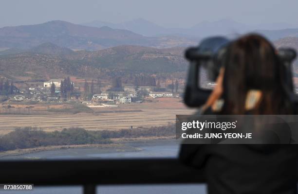 Woman looks through binoculars towards North Korea from a South Korean observation post in Paju near the Demilitarized Zone dividing the two Koreas...