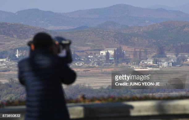 Woman looks through binoculars towards North Korea from a South Korean observation post in Paju near the Demilitarized Zone dividing the two Koreas...