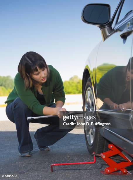 asian woman changing car tire - jacke stock pictures, royalty-free photos & images