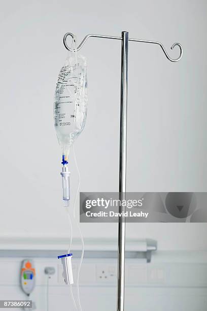 a medical drip on a stand - iv infuus stockfoto's en -beelden