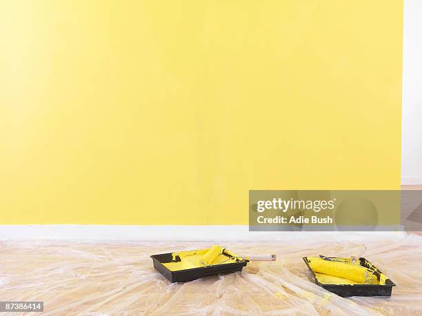 paint rollers on the floor. - paint tray stock-fotos und bilder