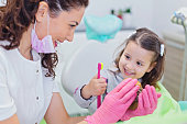 Dentist teaching cute girl about oral hygiene