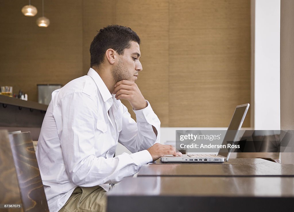 Man sitting at bar on laptop