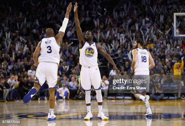 Draymond Green high-fives David West of the Golden State Warriors during their game against the Orlando Magic at ORACLE Arena on November 13, 2017 in...