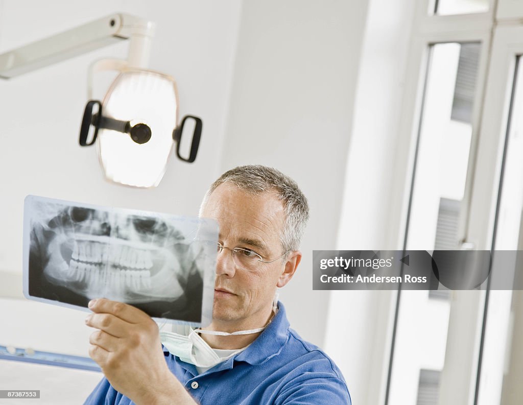 Male dentist looking at x-rays