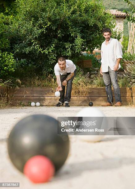 two men playing bocce ball - boules stock-fotos und bilder