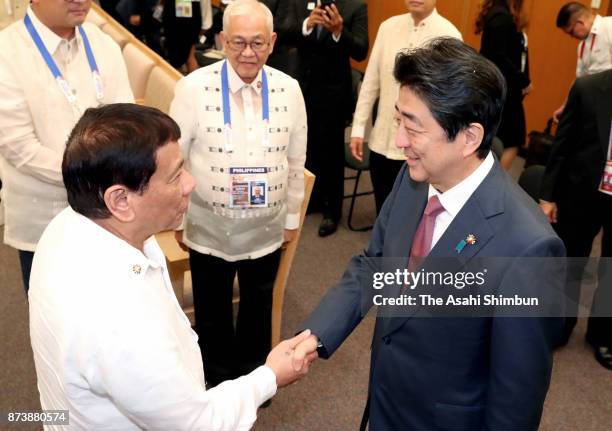 Japanese Prime Minister Shinzo Abe and Philippines President Rodrigo Duterte shake hands prior to their meeting during the ASEAN Summit meeting on...