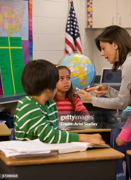 teacher talking to student in classroom - ariel rebel ストックフォトと画像