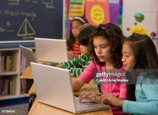 students typing on laptop in classroom - computer lab kids stock pictures, royalty-free photos & images