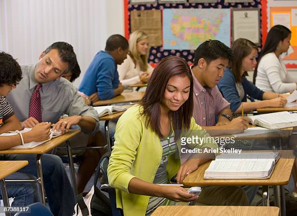 teenage girl text messaging on cell phone in classroom - native korean stock pictures, royalty-free photos & images