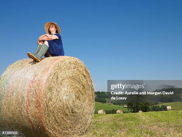 girl sitting on top of bale of hay - reconnecting with nature stock pictures, royalty-free photos & images