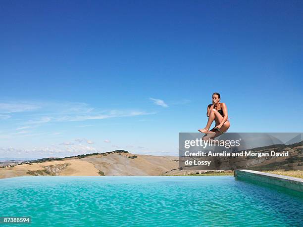 woman jumping in swimming pool - jump in pool stock-fotos und bilder