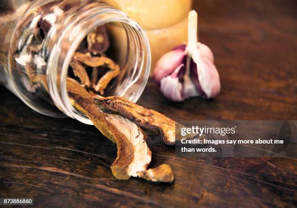 a jar with mushrooms and garlic on wood board. close up. - cèpes photos et images de collection