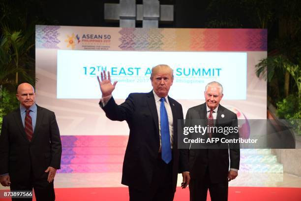 President Donald Trump waves to the press as US National Security Advisor HR McMaster and US Secretary of State Rex Tillerson look on after attending...