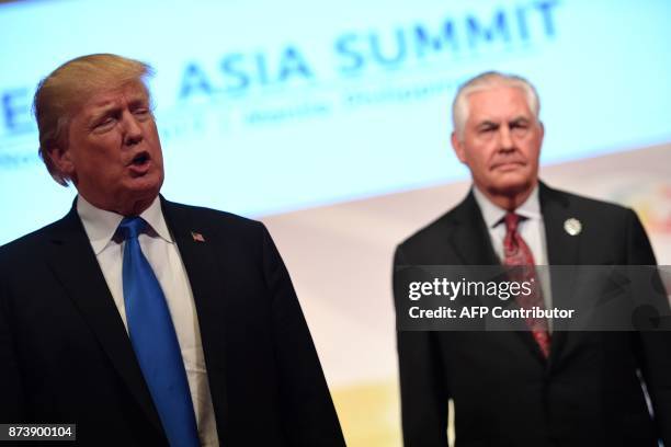 President Donald Trump talks to the press as US Secretary of State Rex Tillerson looks on after attending the 31st Association of Southeast Asian...