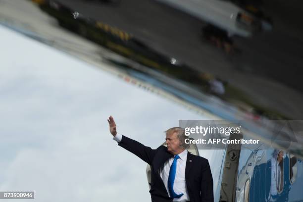 President Donald Trump waves as he boards Air Force One after attending the 31st Association of Southeast Asian Nations Summit in Manila on November...