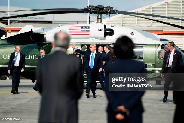 President Donald Trump waves before boarding Air Force One after attending the 31st Association of Southeast Asian Nations Summit in Manila on...