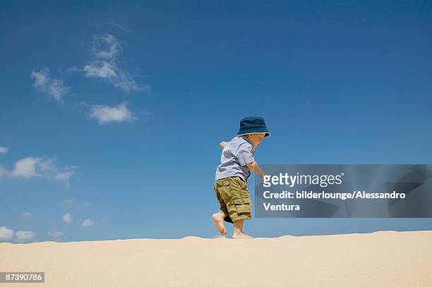 full body portrait of toddler walking on beach - hot boy body stock-fotos und bilder