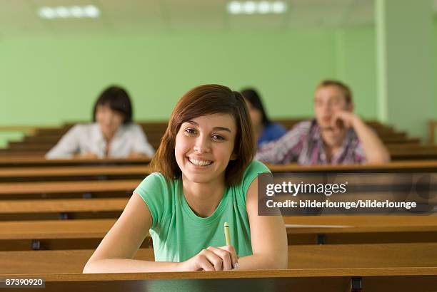 portrait of smiling young student in lecture hall - teachers pet stock pictures, royalty-free photos & images