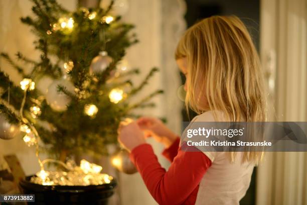 little girl decorating christmas tree - christmas norway stock pictures, royalty-free photos & images