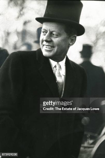 View of US President John F Kennedy , in an overcoat and top hat, as he glances behind him during his Inauguration ceremonies, Washington DC, January...