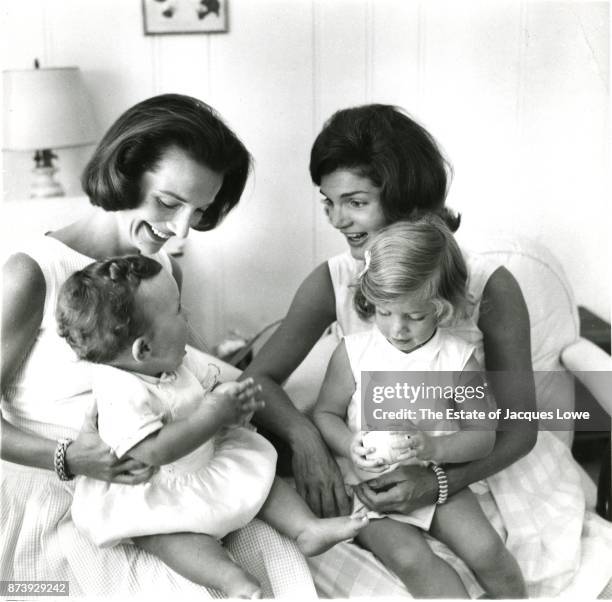 View of Lee Radziwill and her sister Jacqueline Kennedy , as they hold their children, Anthony and Caroline, Hyannis Port, Massachusetts, late 1950s...