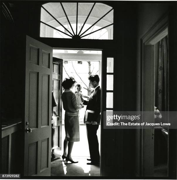 View of married couple Jacqueline Kennedy and Senator John F Kennedy as the latter says goodbye to their daughter Caroline in the doorway of their...