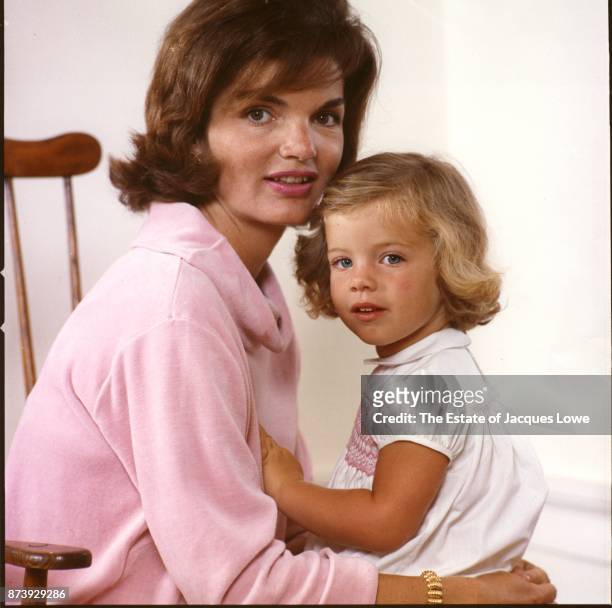Portrait of Jacqueline Kennedy as she holds her daughter Caroline in her lap, Hyannis Port, Massachusetts, Spring or Summer 1959. The photo was taken...
