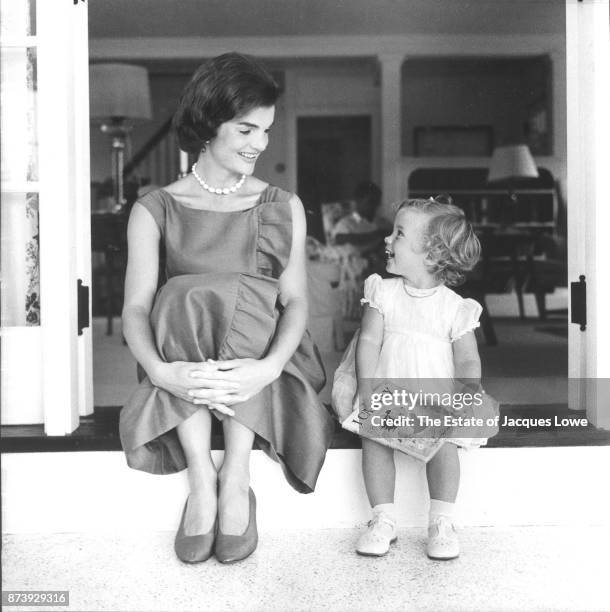 View of Jacqueline Kennedy and her daughter Caroline as they sit side-by-side and share a laugh, Hyannis Port, Massachusetts, Summer 1958. The photo...