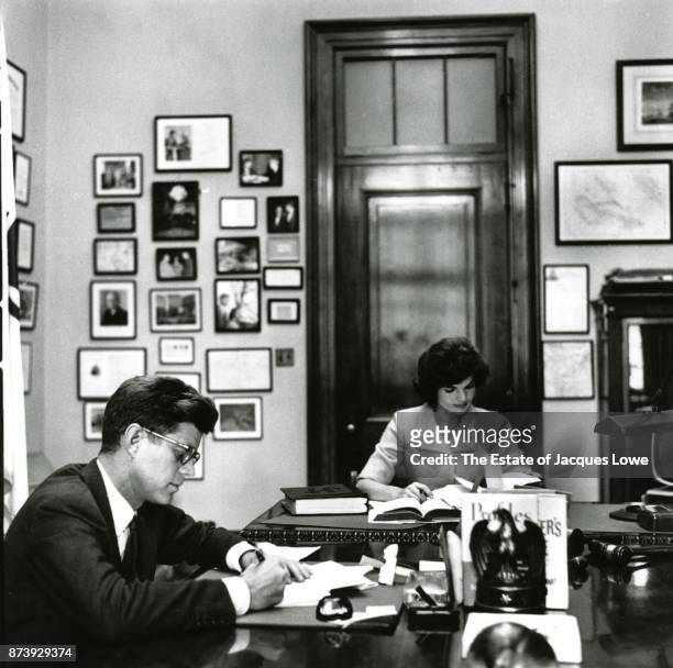 View of married couple Senator John F Kennedy and Jacqueline Kennedy as they work together in the former's Capitol Hill office, Washington DC, Fall...
