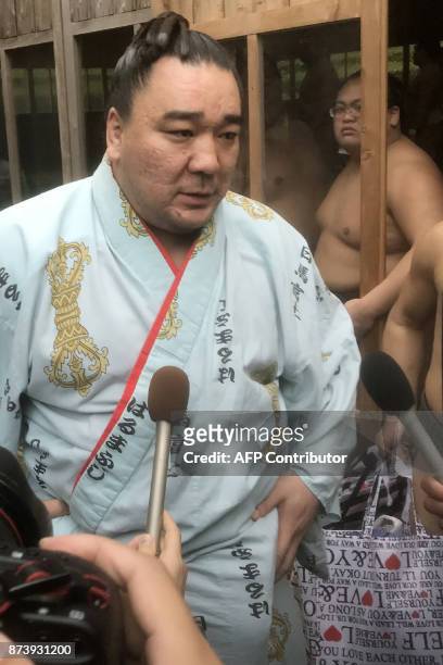Mongolian sumo wrestler yokozuna, or grand champion, Harumafuji speaks with journalists after his morning training in Daizaifu city, Fukuoka...