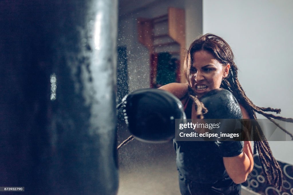 Weibliche kickboxer Ausbildung mit Boxsack