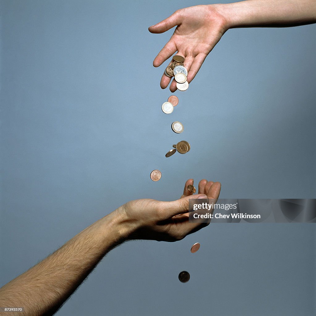 Hands dropping coins