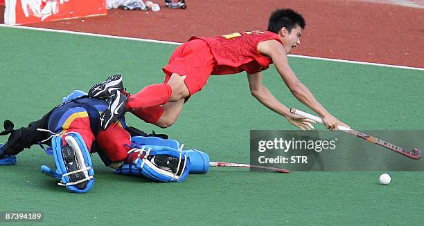 China's Liu Xian Tang collides with Malaysia's goalkeeper Mohammad Fairus Md Wanazir during their match for third and fourth place at the Asia Cup...