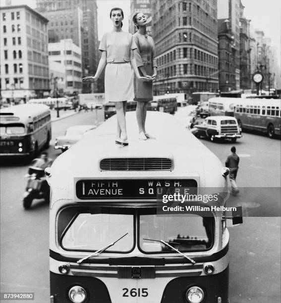 View of American models Dovima and Jean Patchett as they pose on the roof of a city bus on 5th Avenue , New York, New York, 1958. The photo...