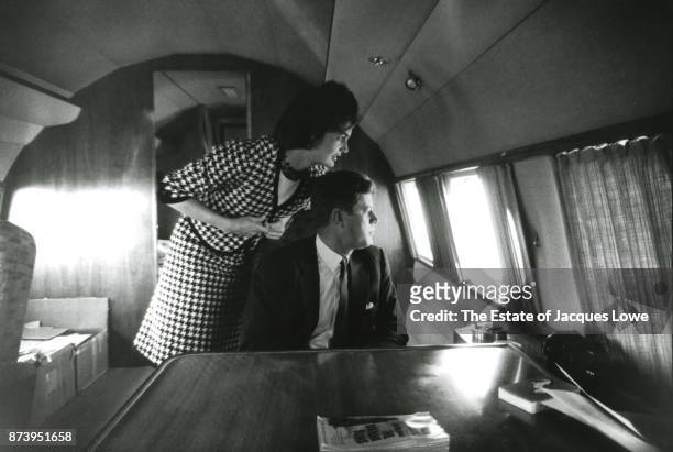 Inside their private plane , married couple Jacqueline Kennedy and Senator John F Kennedy looking out a window at supporters on the tarmac during a...