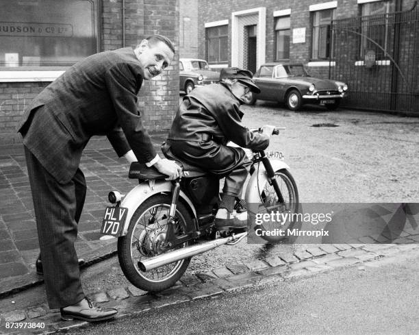 Florrie Ball is given a push off on her new motorbike by insurance broker Arthur Edwards, 11th February 1969.