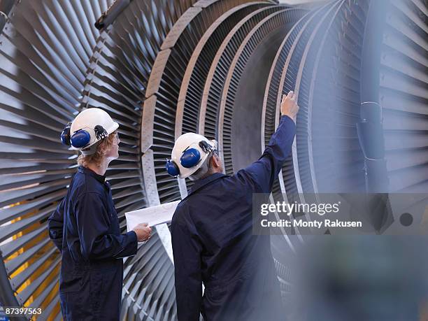 engineers looking at turbine - interested listener stock-fotos und bilder