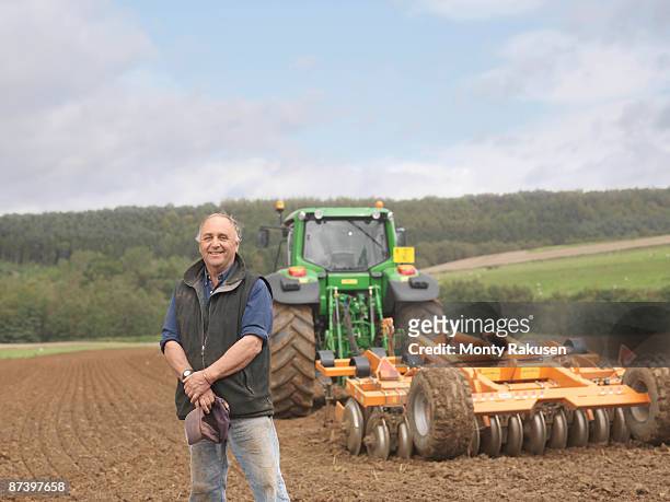 farmer with tractor in field - ara foto e immagini stock