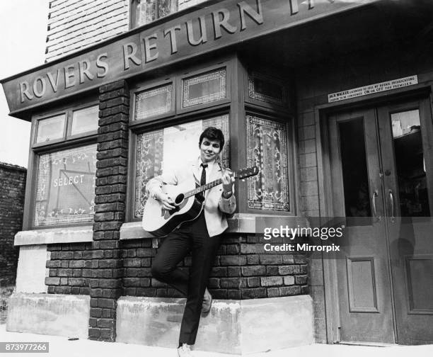 Actor Bill Kenwright who plays Gordon Clegg in the television soap opera Cornation Street, poses in the famous street with his guitar shortly before...