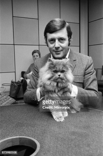 Commentator Michael Aspel at the BBC Studios at Lancaster Gate with a cat who is a contestant in the cat show this weekend, 27th November 1970.