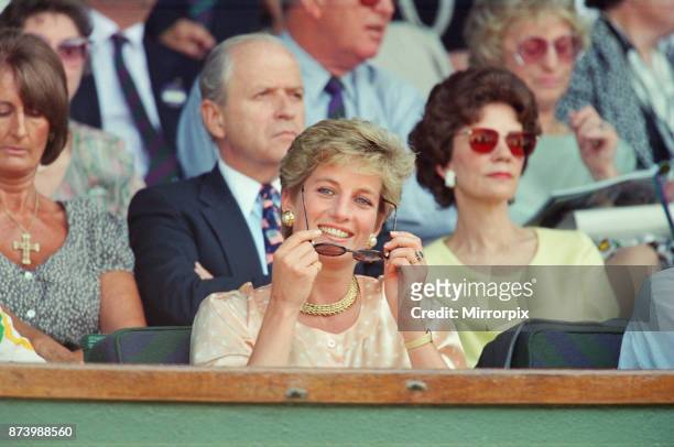 Princess Diana, Princess of Wales, attends the 1993 Men's Singles Wimbledon Tennis Final. She wears or attends to her sunglasses for most of the...
